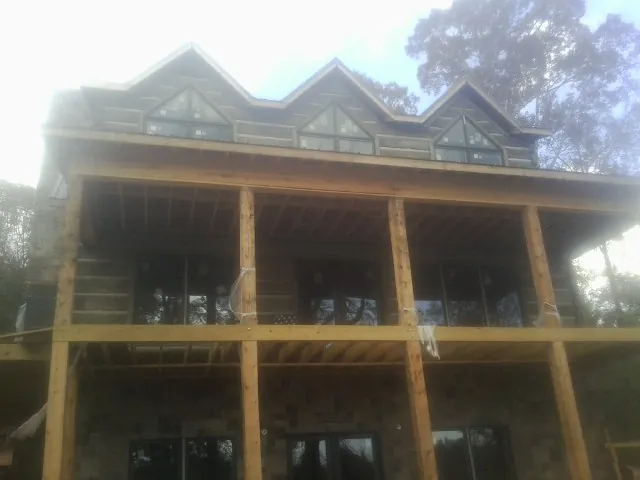 Dormers and porch framing on a large log home under construction — Roof Coating work by our crew in Wallula